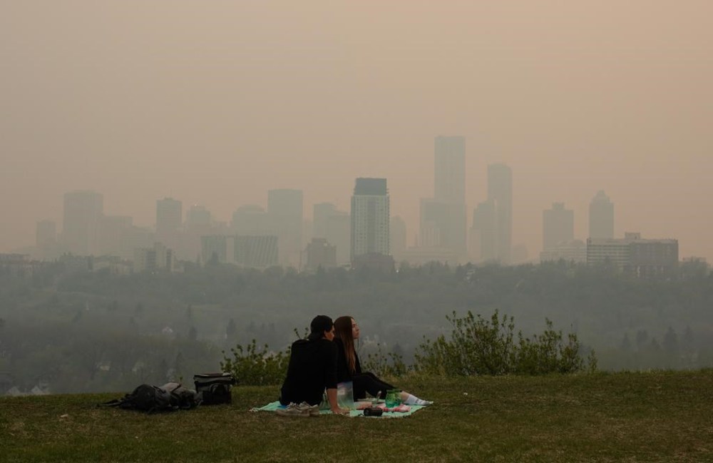 Smoke from wildfires blankets the city as a couple has a picnic in Edmonton last spring. Six members of Congress in the U.S. have written a letter to the Canadian ambassador, demanding what our government intends to do about the wildfire smoke drifting south of the border. (File)