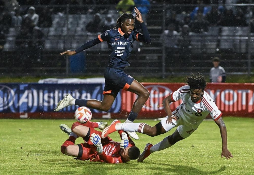 CS Saint-Laurent goalkeeper Konstantinos Maniatis, bottom left, stops Toronto FC forward Deandre Kerr, right, as Saint-Laurent's Cedrick Adamou defends during second half Canadian Championship quarterfinal soccer action in Montreal, Wednesday, May 8, 2024. THE CANADIAN PRESS/Graham Hughes