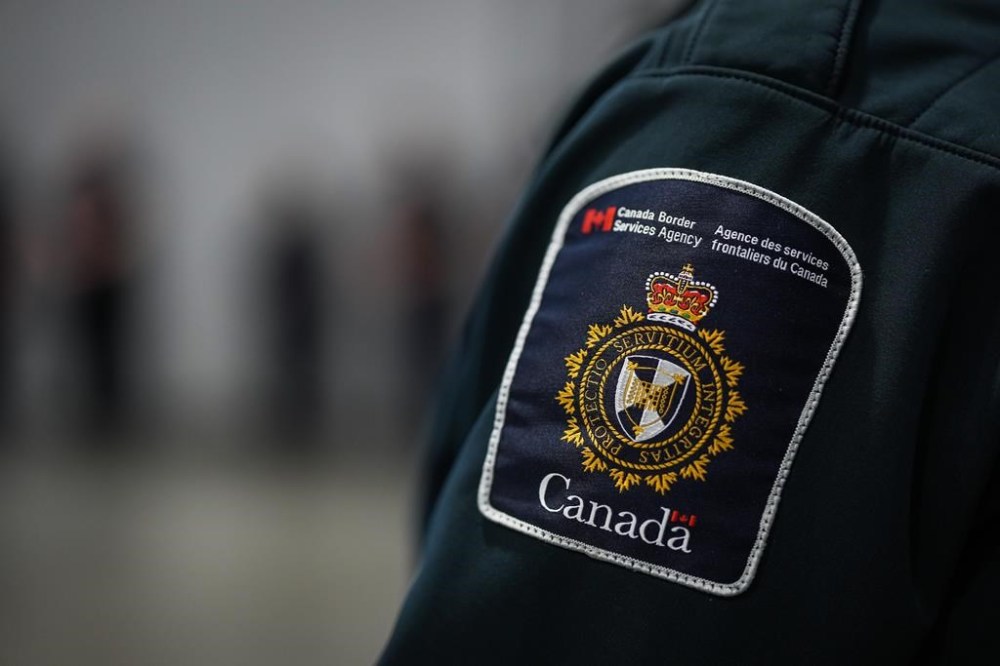 The union representing workers at the Canada Border Services Agency (CBSA) says a strike affecting Canada’s borders this summer is possible. A patch is seen on the shoulder of a Canada Border Services Agency officer's uniform as he listens during an announcement in Tsawwassen, B.C., Friday, Dec. 16, 2022. THE CANADIAN PRESS/Darryl Dyck