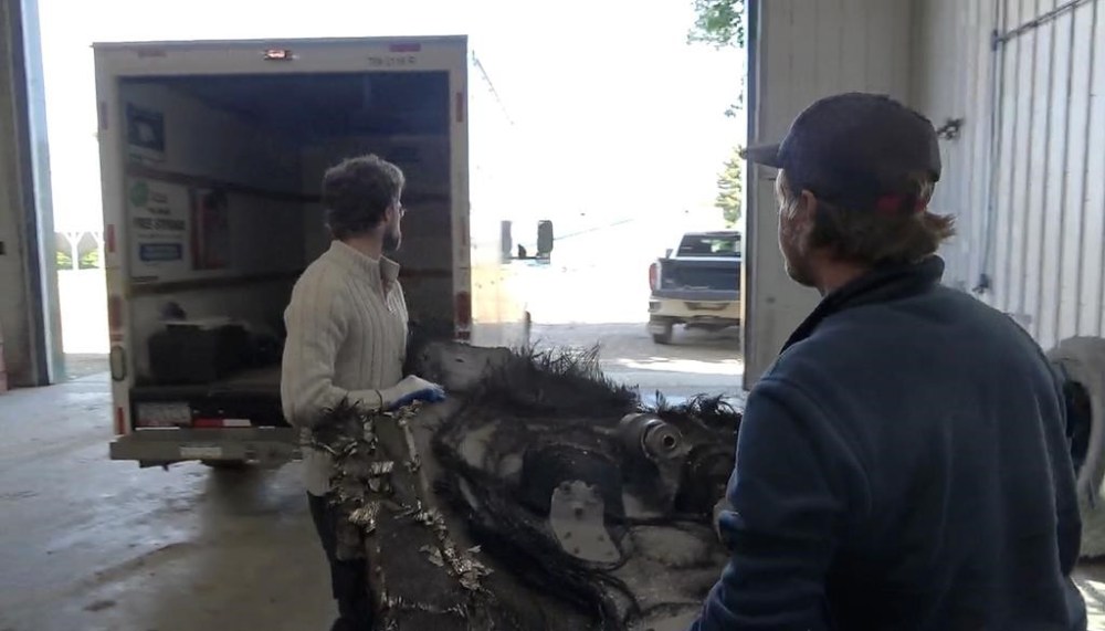 Two men with SpaceX, who didn't provide their names, retrieve space junk that fell earlier this year from one of its spacecraft, in a still frame taken from video footage made near Ituna, Sask., on Tuesday, June 11, 2024. THE CANADIAN PRESS/Jeremy Simes