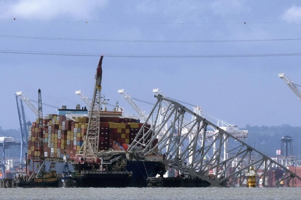 FILE - The collapsed Francis Scott Key Bridge rests on the container ship Dali, May 12, 2024, in Baltimore, as seen from Riviera Beach, Md. Crew members on the cargo ship Dali can head home as soon as Thursday, June 20, 2024, under an agreement that allows lawyers to question them amid ongoing investigations into what led to the deadly collapse of Baltimore's Francis Scott Key Bridge. (AP Photo/Mark Schiefelbein, File)
