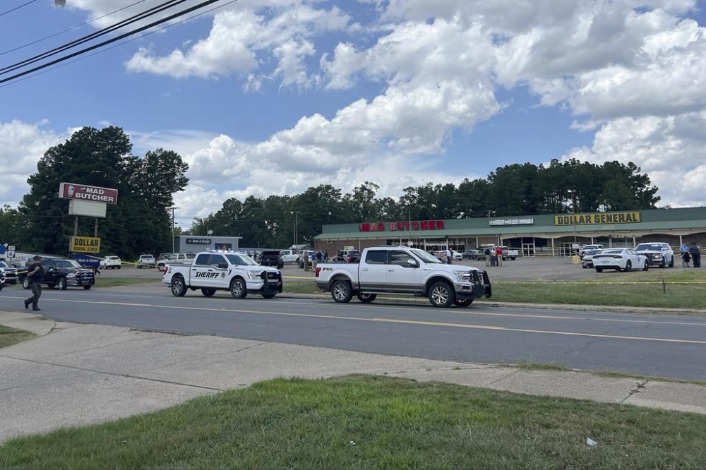 Police vehicles remain on the scene of a shooting at the Mad Butcher grocery store, Friday, June 21, 2024, Frodyce, Ark. (Ainsley Platt/Arkansas Democrat-Gazette via AP)