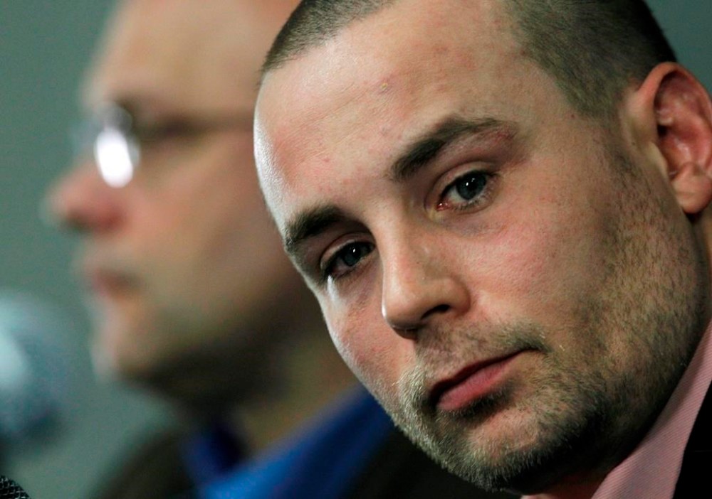 Boston Bruins forward Marc Savard reacts while General Manager Peter Chiarelli, left, speaks during a news conference, Monday, Feb. 7, 2011, in Boston. THE CANADIAN PRESS/AP-Elise Amendola