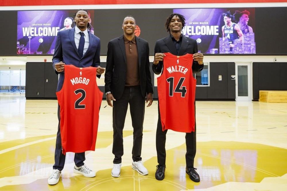 Toronto Raptors draft picks Jonathan Mogbo, left, and Ja’Kobe Walter, pose with Toronto Raptors president Masai Ujiri following a press conference at the OVO Athletic Centre in Toronto on June 28, 2024. THE CANADIAN PRESS/Cole Burston