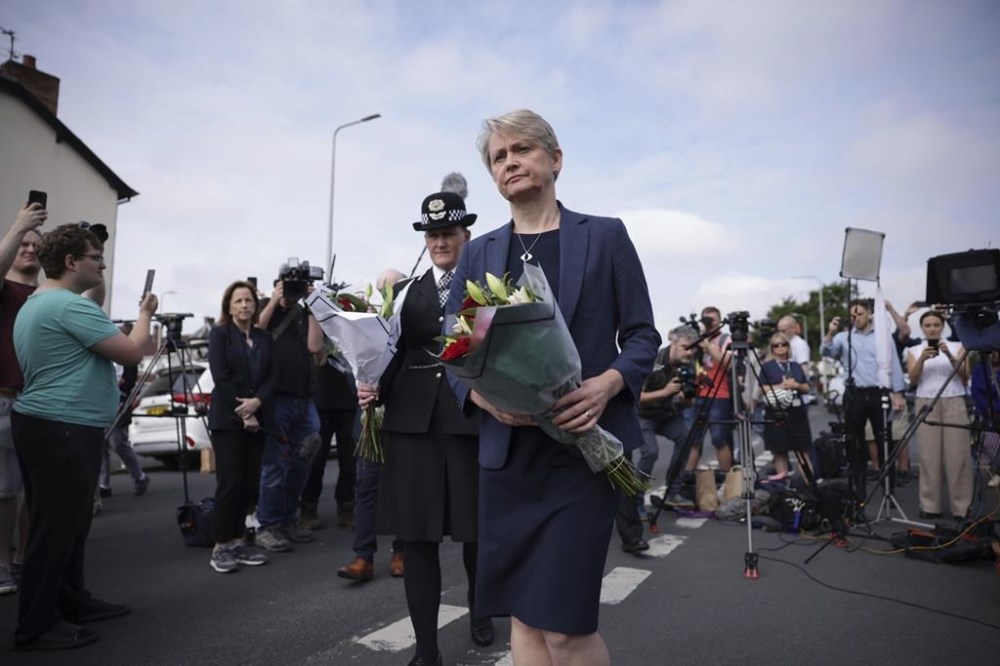 Home Secretary Yvette Cooper brings flowers to the scene in Hart Street where two children died and nine were injured in a knife attack during a Taylor Swift event at a dance school on Monday, in Southport, England, Tuesday, July 30, 2024. Taylor Swift says she is “completely in shock” after two children died in a stabbing attack in a dance and yoga class themed on the singer. (James Speakman/PA via AP)