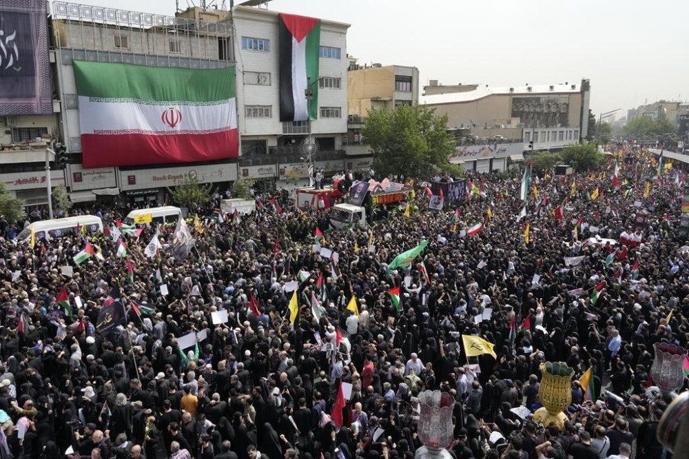Iranians follow a truck, center, carrying the coffins of Hamas leader Ismail Haniyeh and his bodyguard who were killed in an assassination blamed on Israel on Wednesday, during their funeral ceremony at Enqelab-e-Eslami (Islamic Revolution) Sq. in Tehran, Iran, Thursday, Aug. 1, 2024. (AP Photo/Vahid Salemi)