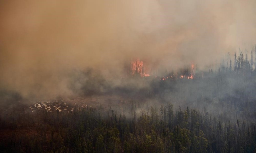 A wildfire burns in northern Manitoba near Flin Flon, as seen from a helicopter surveying the situation on May 14. The Brandon Police Service reports that the Red Cross has informed them that 225 evacuees from Manto Sipi Cree Nation and St. Theresa Point First Nation are being lodged at six hotels in Brandon. (The Canadian Press)