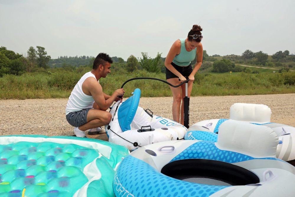 Luis Alvarenga and Loren Lobreau inflate tubes at Kirkham Bridge west of Brandon. (Tim Smith/The Brandon Sun)