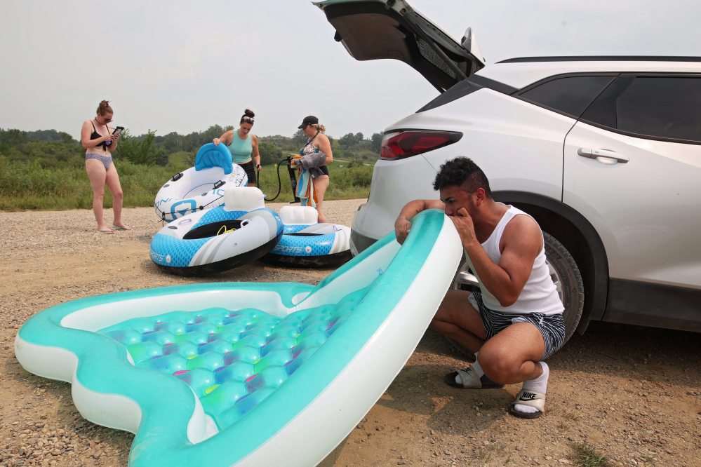 Tocher, Lobreau, Kowalchuk and Alvarenga inflate rafts for their trip down the Little Saskatchewan River. (Tim Smith/The Brandon Sun)