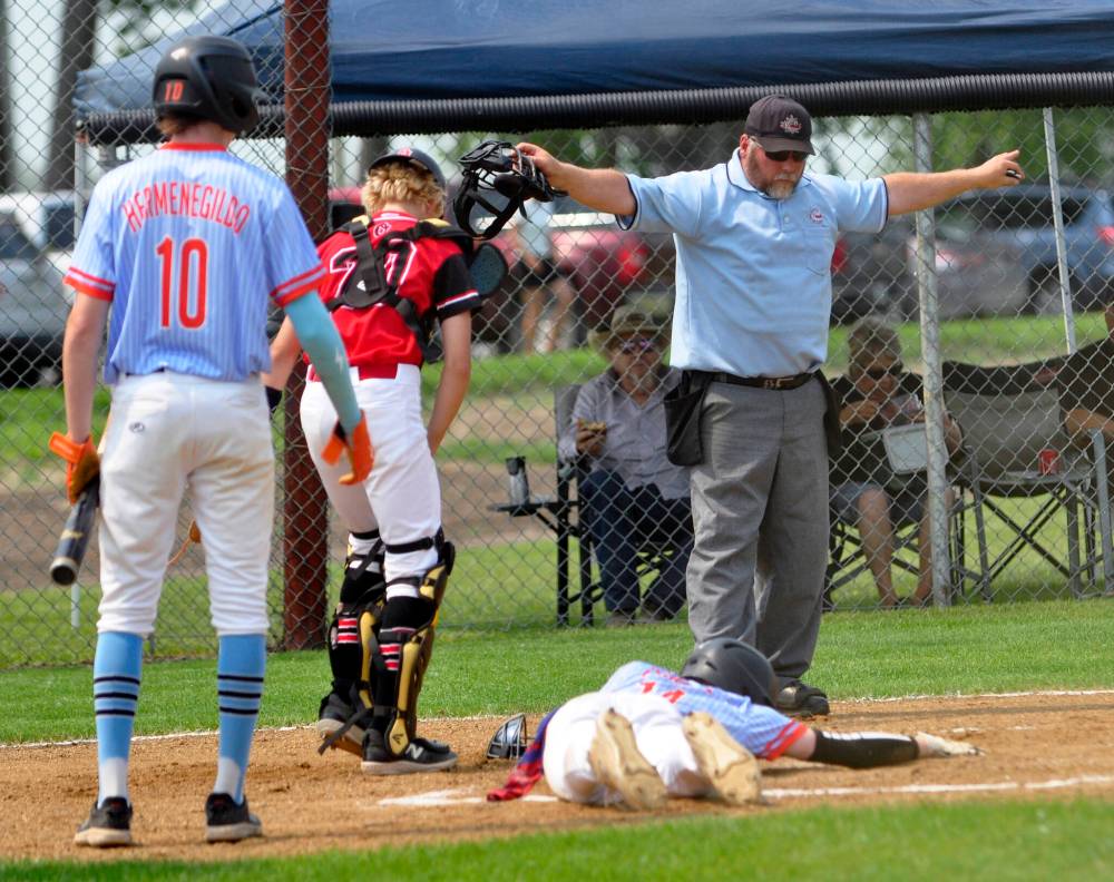 Brandon Marlins shortstop Lucas Gamache was injured on this play after sliding home for an inside-the-park homerun, with his team going on to post a 14-5 win over Oildome. Looking on are Oildome catcher Jonah Artz and Marlins third baseman Karter Hermenegildo. The Marlins improved to 2-0 after erasing a 3-0 deficit to defeat Midwest 12-3 during their second game. Action resumes today and concludes on Sunday.