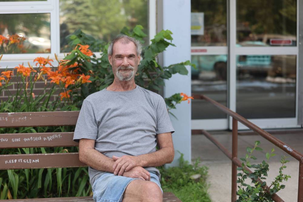 GMC camper owner Doug Broome sits in front of the Princess Park Apartments after the fire incident. (Abiola Odutola/The Brandon Sun)