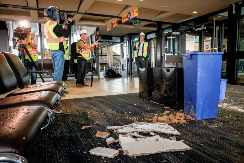 Chris Miles, right, Chief Operating Officer, of the Calgary Airport, speaks to members of the media on a tour of a closed concourse as repairs are underway at the Calgary International Airport after parts of its domestic terminal building were closed late Monday due to damage caused by hail and heavy rainfall, in Calgary, Alta., Aug. 6, 2024. The Calgary Airport Authority says it will take at least a year and a half to fix part of its domestic terminal that was hammered by hail earlier this month.
It says Concourse B will be closed while restoration work is done. THE CANADIAN PRESS/Jeff McIntosh