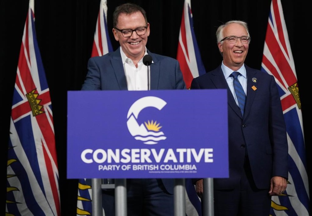 B.C. Conservative Leader John Rustad, right, and BC United Leader Kevin Falcon laugh while responding to questions during a news conference in Vancouver, on Wednesday, Aug. 28. Falcon has announced that he is suspending BC United's election campaign and is encouraging supporters to instead back the rival BC Conservative Party. THE CANADIAN PRESS/Darryl Dyck