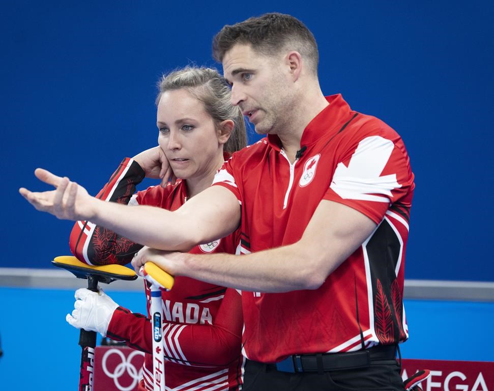 Canada’s Rachel Homan and John Morris discuss a shot during preliminary round mixed curling against Czech Republic Sunday, February 6, 2022 at the 2022 Winter Olympics in Beijing. THE CANADIAN PRESS/Ryan Remiorz