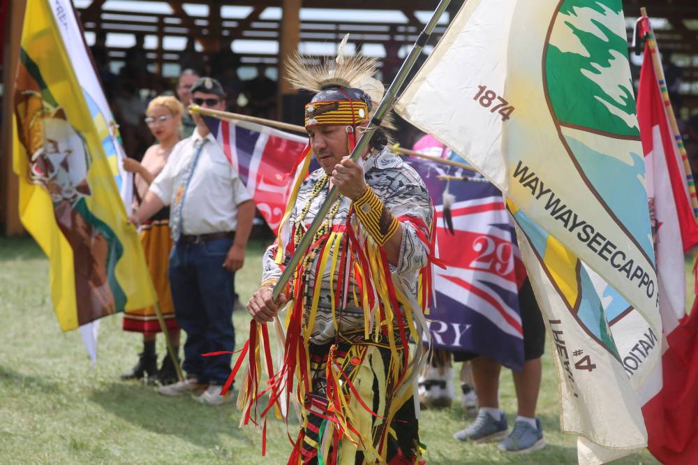 A flag-bearer for the Waywayseecappo Treaty 4 anniversary commemoration participates in the powwow Grand Entry on Saturday. (Geena Mortfield/The Brandon Sun)