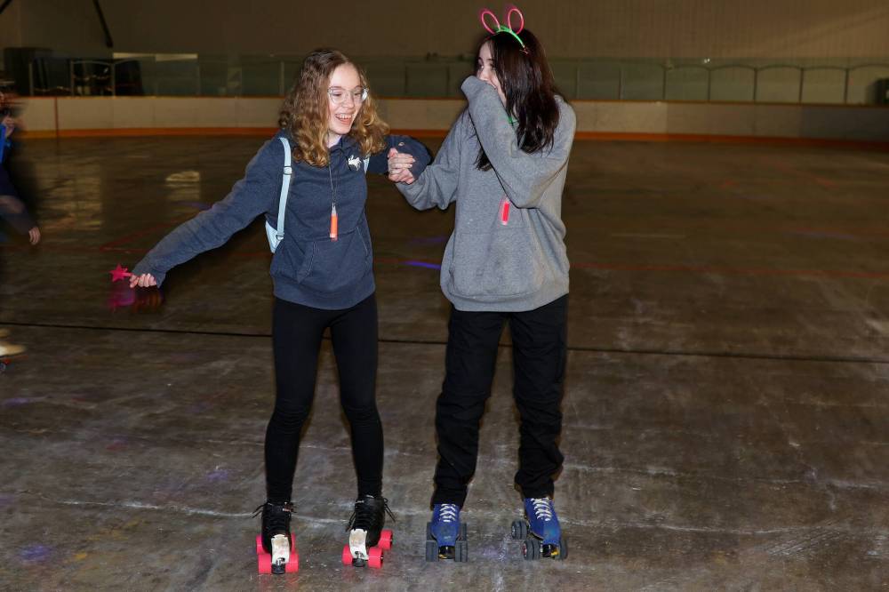 Athena Ringland and Leah Thurston roller-skate during a roller disco event at the Sportsplex arena last year. The Last Dance Roller Disco will take place at the Sportsplex arena on Aug. 22. (File)