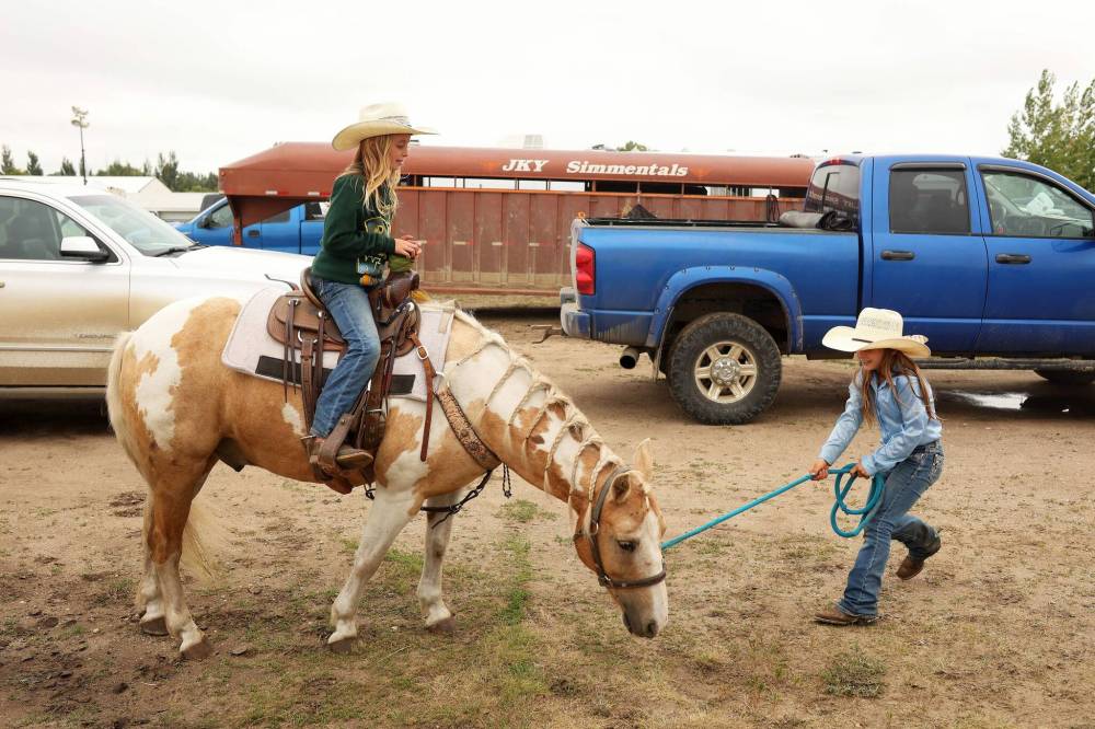Dally Brown (right) leads friend Finley Ross atop horse Bandit.
