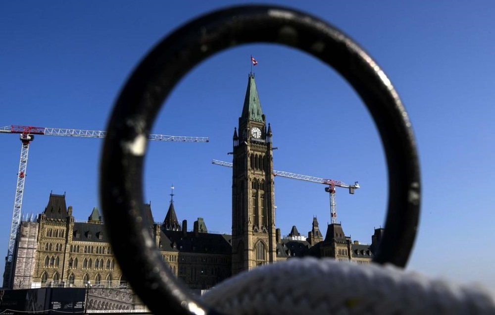 Centre Block and the Peace Tower are seen past a metal fence along the lawn of Parliament Hill, in Ottawa, on Thursday, Sept. 5, 2024. Members of Parliament on the public safety and national security committee voted unanimously to launch an investigation into an alleged Russian ploy to dupe right-wing influencers into sowing division among Americans. THE CANADIAN PRESS/Justin Tang
