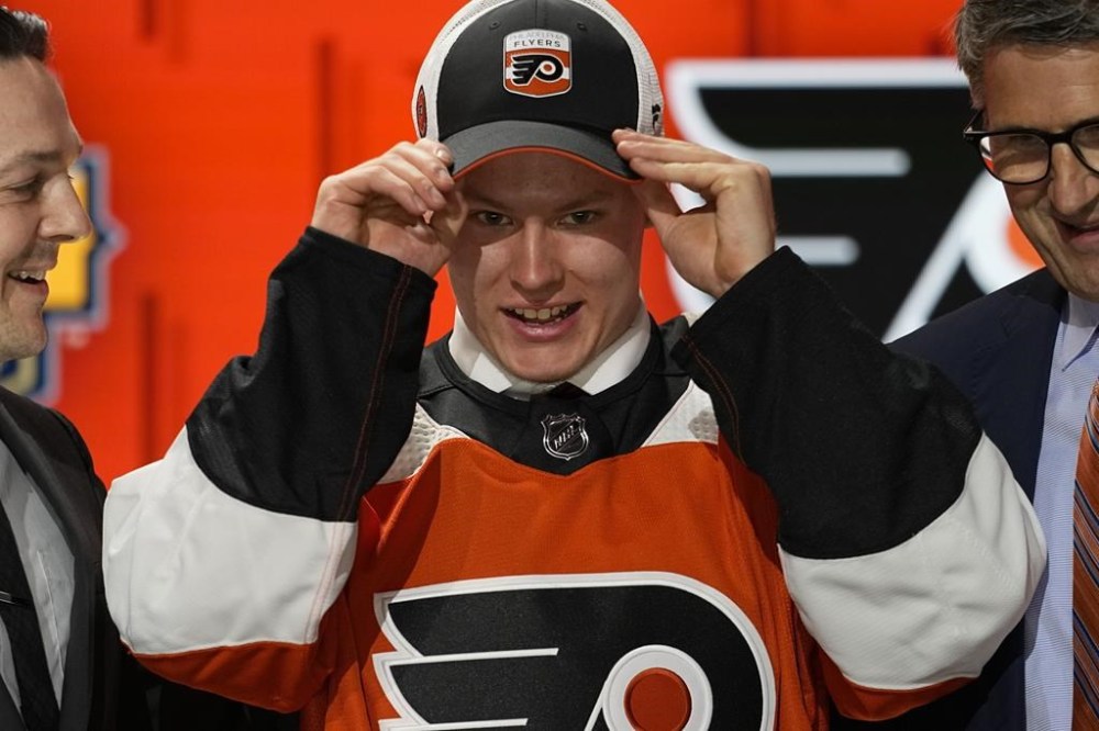 FILE - Matvei Michkov adjust his Philadelphia Flyers hat after being picked by the team during the first round of the NHL hockey draft Wednesday, June 28, 2023, in Nashville, Tenn. (AP Photo/George Walker IV, File)