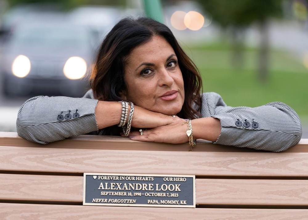 Raquel Ohnona Look poses by a bench memorialized with the name of her son, Alexandre Look, in the park named after him in Montreal, Tuesday, Oct. 1, 2024. Look was killed on October 7, 2023 in the Hamas attack at a music festival in Israel. THE CANADIAN PRESS/Christinne Muschi