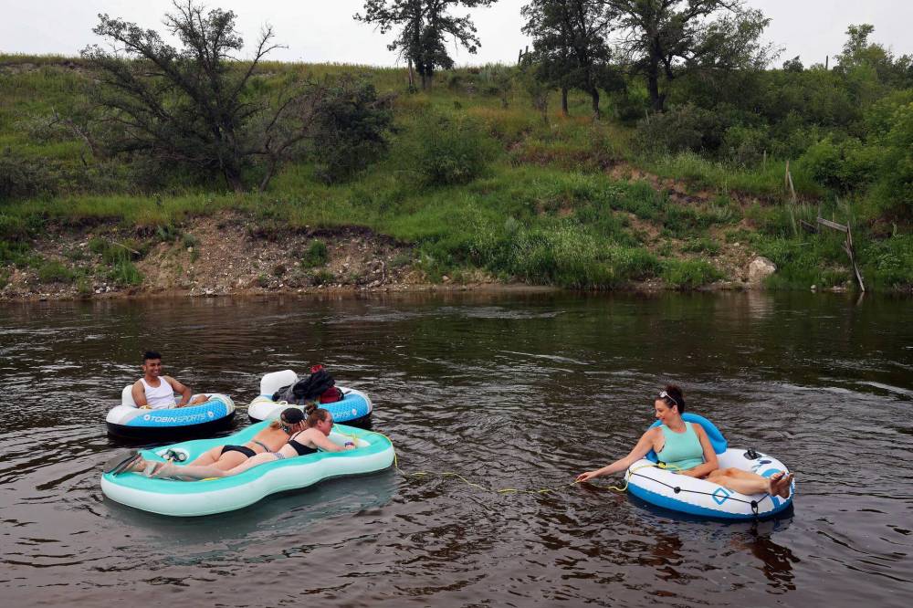 Friends Luis Alvarenga, Cassandra Kowalchuk, Jodie Tocher and Loren Lobreau float down the Little Saskatchewan River west of Brandon on July 22 — which Alex Crawford notes was the hottest day in recorded human history. (Tim Smith/The Brandon Sun)