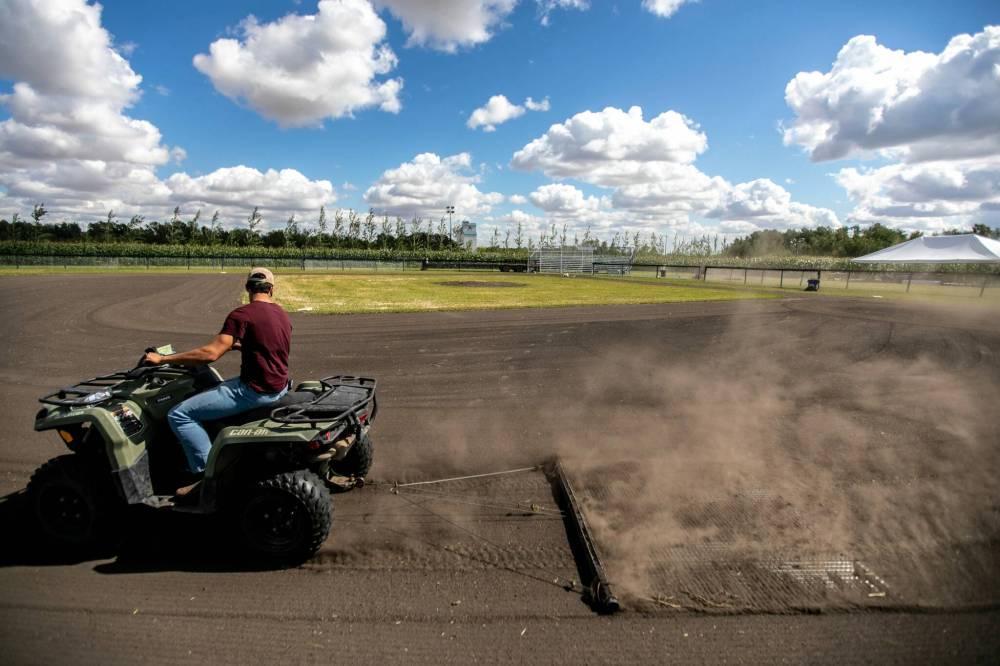 Jace Guilford drags the infield at the Field of Dreams baseball diamond near Clearwater, Manitoba on Thursday. (Mikaela MacKenzie/Winnipeg Free Press)
