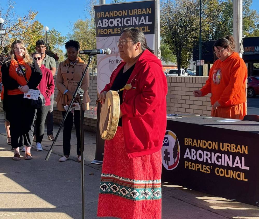 Susie McPherson-Derendy, one of the knowledge keepers at Brandon University and a counsellor at the Healing and Wellness Centre, sings a prayer during the raising of the Indigenous flag at Brandon City Hall Friday morning. (Michele McDougall/The Brandon Sun)