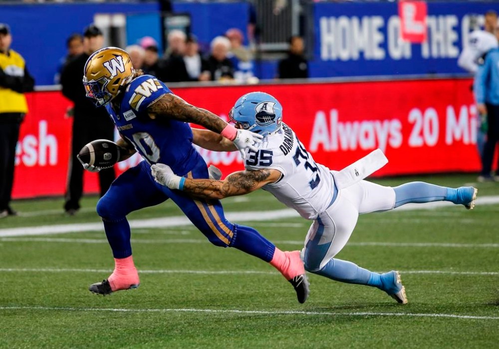 Toronto Argonauts' Isaac Darkangelo (35) stops Winnipeg Blue Bombers' Brady Oliveira (20) from scoring a touchdown during first half CFL action in Winnipeg Friday, October 11, 2024. THE CANADIAN PRESS/John Woods