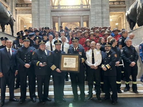 Some of the first responders awarded the Order of the Buffalo Hunt by Manitoba Premier Wab Kinew, front left, are seen on the staircase of the legislature in Winnipeg on Monday Oct. 28, 2024. Kinew awarded the order to 134 responders who leapt into action following a bus crash near Carberry, Man., in June 2023 that killed 17 people. THE CANADIAN PRESS/Steve Lambert