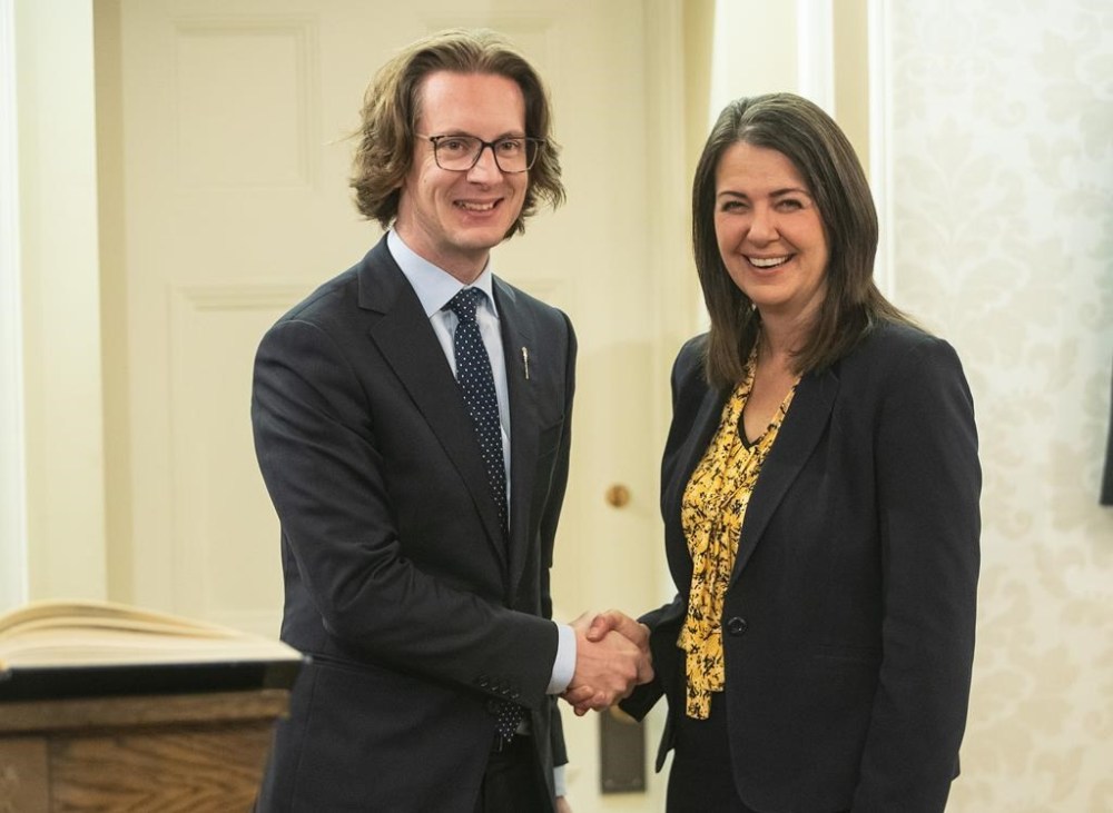 Nate Glubish shakes hands with Alberta Premier Danielle Smith after Glubish was sworn into cabinet as Minister of Technology and Innovations in Edmonton, Monday, Oct. 24, 2022. The Alberta government is making changes to strengthen privacy rules, including a ban on public bodies such as schools and municipalities selling private information. THE CANADIAN PRESS/Jason Franson