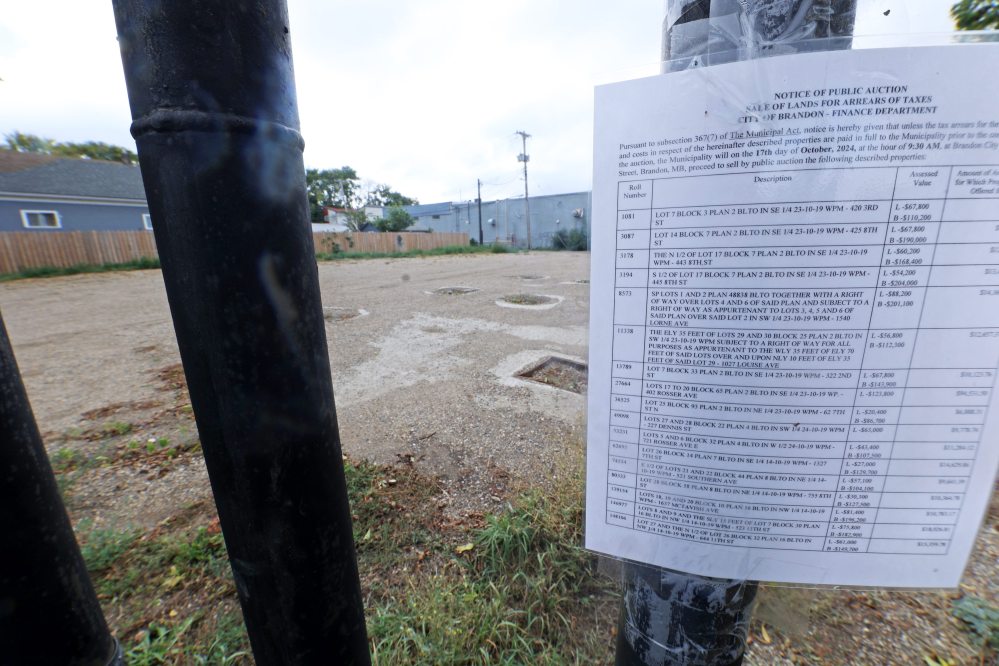 A City of Brandon notice of public auction is fixed to a sign outside the former Esso station at 402 Rosser Avenue on Sept. 18. The station was bulldozed last November and the city has now bought the property for development or green space. (File)