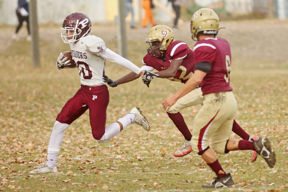 Emmanuel Adetoro (82) of Crocus tries to pull down a St. Paul's player.