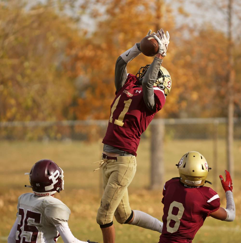 Simon Leckie (11) of Crocus Plainsmen catches the ball for an interception against St. Paul's Crusaders.