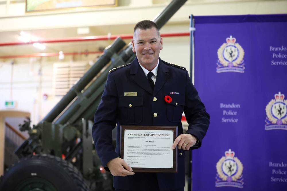 Bates holds up his certificate of appointment during Wednesday’s ceremony.