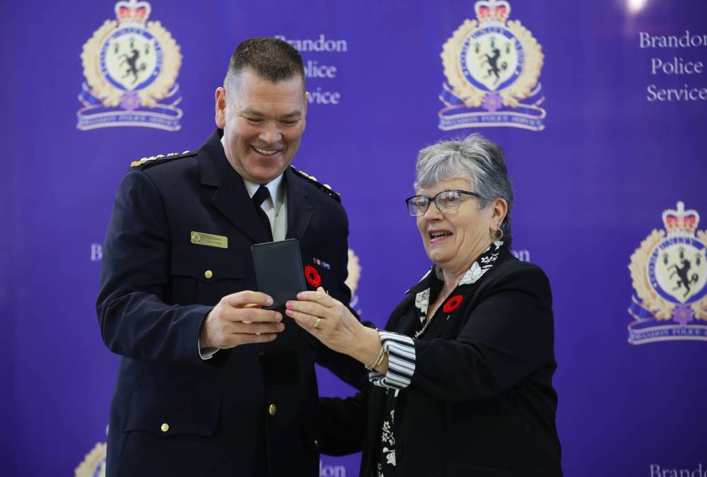 Brandon Police Board chair Deb Arpin presents new Brandon Police Service Chief Tyler Bates with his badge and his certificate of appointment during his swearing-in ceremony at the Brandon Armoury on Wednesday. (Photos by Tim Smith/The Brandon Sun)