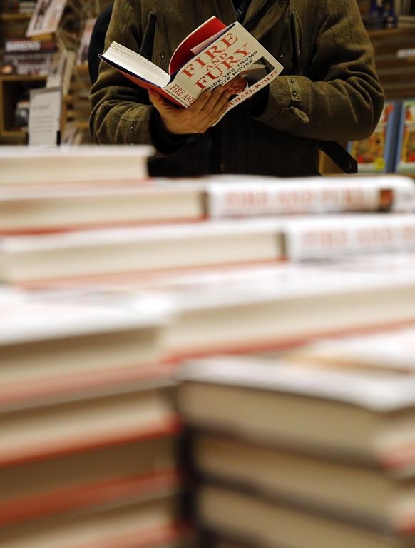 FILE - A customer looks at a copy of Michael Wolff's