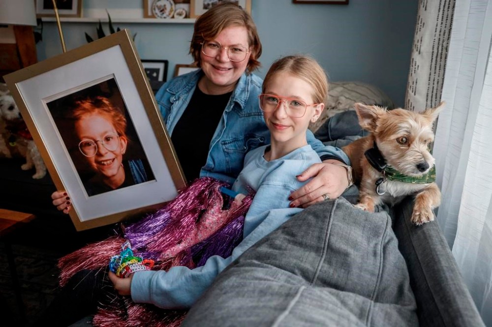 Heather Roy, her daughter, Harper, 12, and dog Dulce, pose with a photo of Harper's big sister Evelyn, who died of cancer in 2020, in Calgary, on Tuesday, Dec. 3, 2024. THE CANADIAN PRESS/Jeff McIntosh