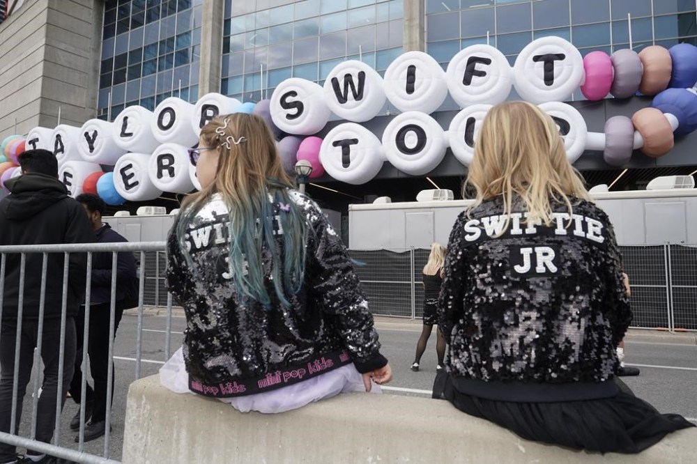 Fans pose for a photo as they gather outside Toronto's Rogers Centre before going to see Taylor Swift perform in the opening show for her Eras Tour on Nov. 14, 2024. THE CANADIAN PRESS/Chris Young