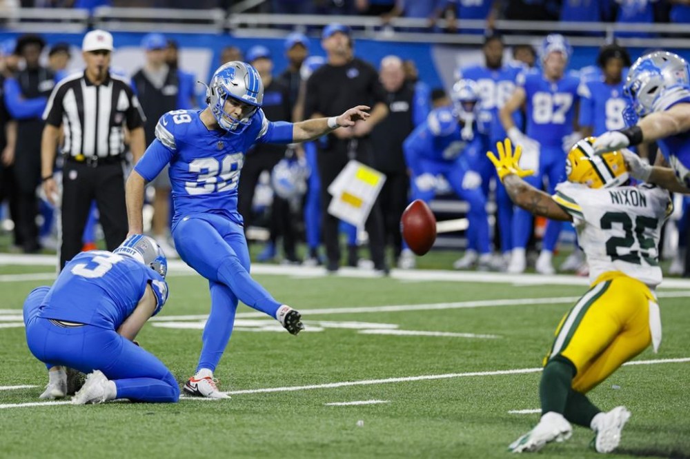 Detroit Lions place kicker Jake Bates (39) kicks a game-winning field goal from the hold of Jack Fox (3) against the Green Bay Packers during the second half of an NFL football game in Detroit, Thursday, Dec. 5, 2024. (AP Photo/Duane Burleson)