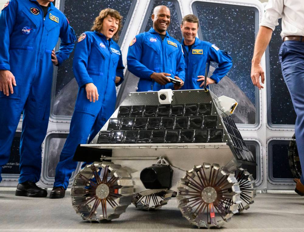Prime Minister Justin Trudeau (right) tries to see if the remote controlled lunar rover being tested out by NASA astronaut Victor Glover (centre) will run over his foot or stop automatically, as he meets with the crew of the Artemis II, Canadian Space Agency astronaut Jeremy Hansen (second from right) and NASA astronauts Glover, Christina Hammock Koch and Reid Wiseman, at the Canada Aviation and Space Museum in Ottawa in 2023. (File)