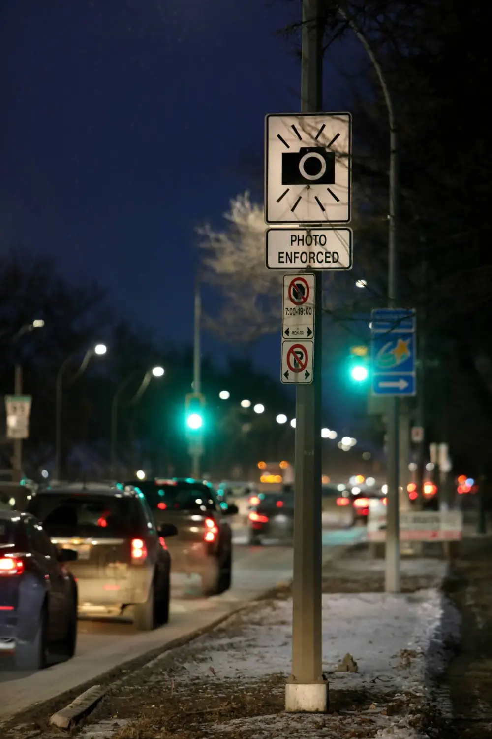 A sign letting motorists know there is a red-light camera in the area is seen on a busy roadway in Winnipeg. A City of Brandon resolution to allow municipal governments to implement red light cameras and photo radar was passed Wednesday at the Association of Manitoba Municipalities (AMM) fall convention in Winnipeg. (File)