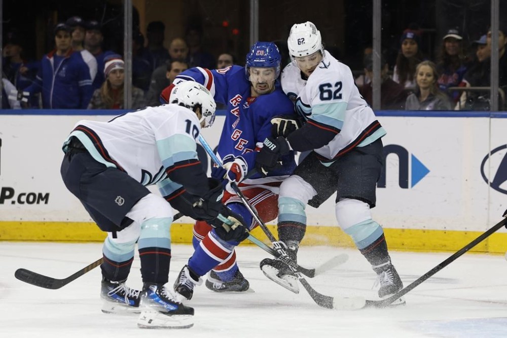 New York Rangers' Chris Kreider (20) attempts to shoot between Seattle Kraken's Matty Beniers (10) and Brandon Montour (62) during the third period of an NHL hockey game, Sunday, Dec. 8, 2024, in New York. (AP Photo/Rich Schultz)