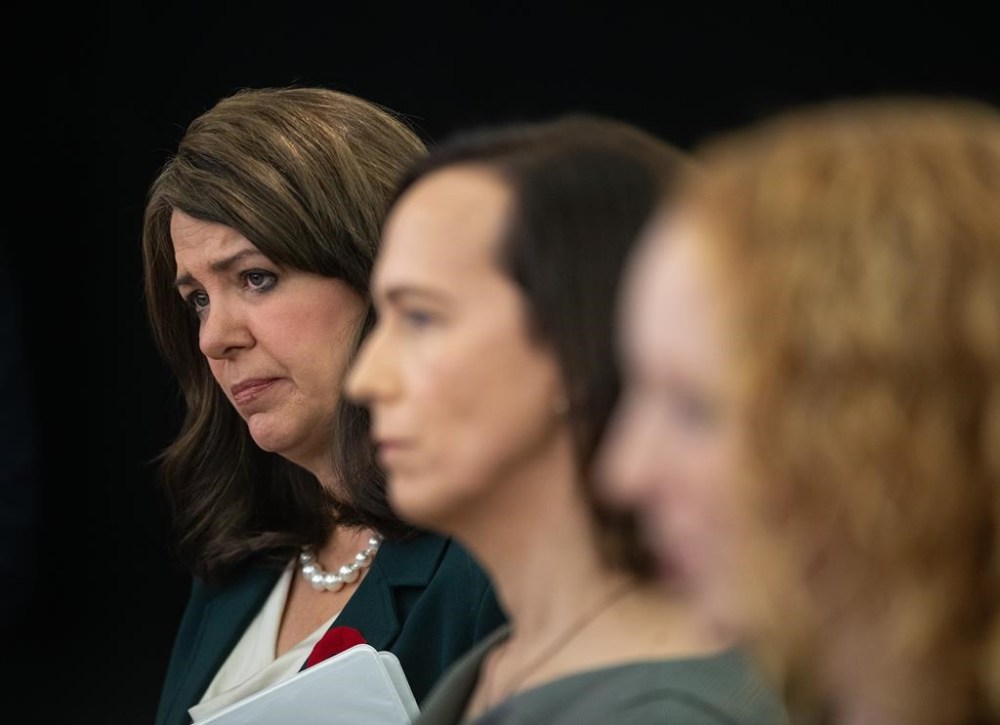 Alberta Premier Danielle Smith and Tiffany Gillis watch as Kellie-Lynn Pirie, not pictured, speaks about Smith introducing three new bills to do with transgender issues in Edmonton, Thursday, Oct. 31, 2024. THE CANADIAN PRESS/Jason Franson