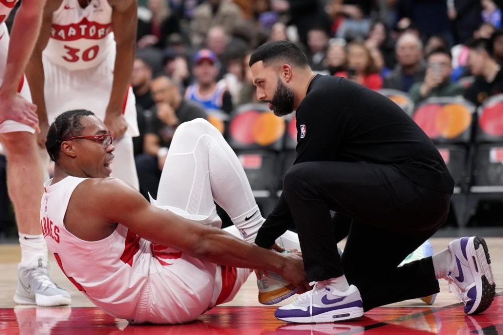 Toronto Raptors forward Scottie Barnes (4) is tended to by a team trainer after getting hurt during second half NBA basketball action against the New York Knicks, in Toronto on December 9, 2024. THE CANADIAN PRESS/Nathan Denette