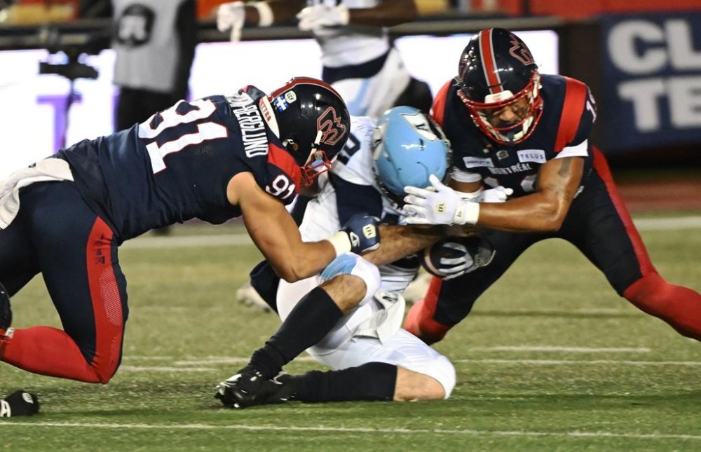 Toronto Argonauts quarterback Chad Kelly (12) is tackled by Montreal Alouettes defensive lineman Isaac Adeyemi-Berglund (91) and Montreal Alouettes linebacker Geoffrey Cantin-Arku (19) during first quarter CFL Eastern Conference Final football action Saturday, November 9, 2024 in Montreal. THE CANADIAN PRESS/Graham Hughes