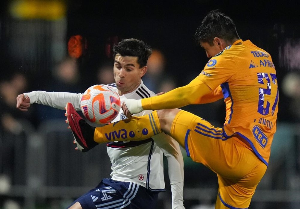 Tigres UANL's Jesus Alberto Angulo, right, and Vancouver Whitecaps' Brian White vie for the ball during the second half of a CONCACAF Champions Cup soccer match, in Langford, B.C., on Wednesday, Feb. 7, 2024. THE CANADIAN PRESS/Darryl Dyck