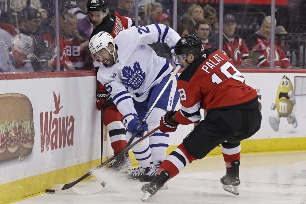 Toronto Maple Leafs defenseman Conor Timmins (25) battles for the puck with New Jersey Devils left wing Ondrej Palat (18) during the second period of an NHL hockey game Tuesday, Dec. 10, 2024, in Newark, N.J. (AP Photo/Adam Hunger)