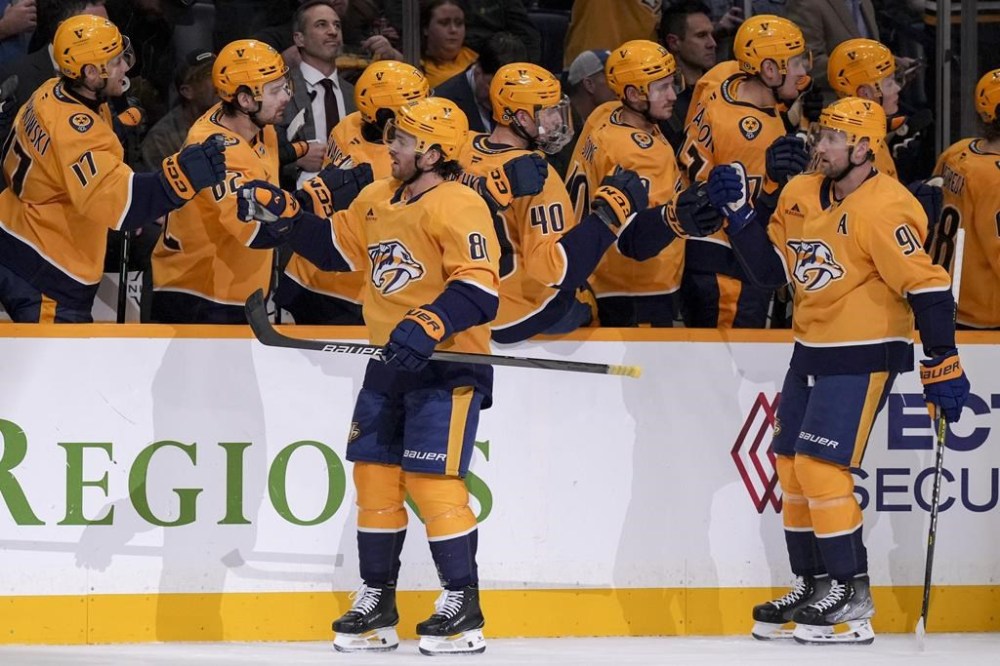 Nashville Predators Jonathan Marchessault (81) and Steven Stamkos (91) celebrate with teammates after a goal during the first period of an NHL hockey game against the Calgary Flames, Tuesday, Dec. 10, 2024, in Nashville, Tenn. (AP Photo/George Walker IV)
