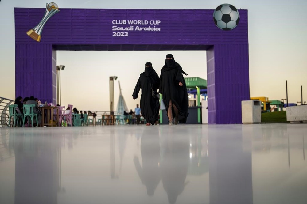 FILE - Women walk in front of a fan zone during the Soccer Club World Cup at the Jeddah Corniche in Jeddah, Saudi Arabia, Wednesday, Dec 13, 2023. (AP Photo/Manu Fernandez, File)