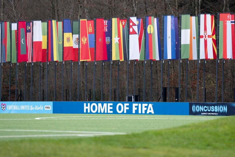 A soccer pitch with flags of the member states in the background is seen at the headquarters of the soccer association FIFA in Zurich, Switzerland, Wednesday, Dec. 11, 2024. (Til Buergy/Keystone via AP)